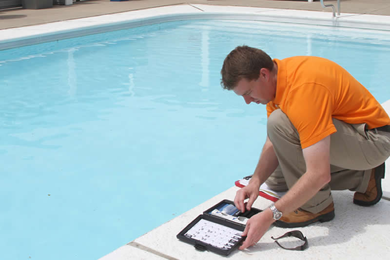 Male pool technician testing water chemical