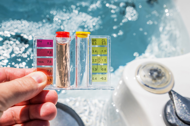 Hot Tub Water Quality Check by Using Chemical Testing Kit. pH, Chlorine and Bromine Concentration. Garden SPA Water Maintenance.