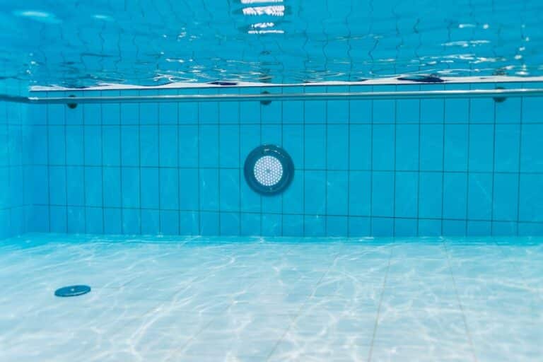 Clean blue water in a swimming pool, view from under the wate