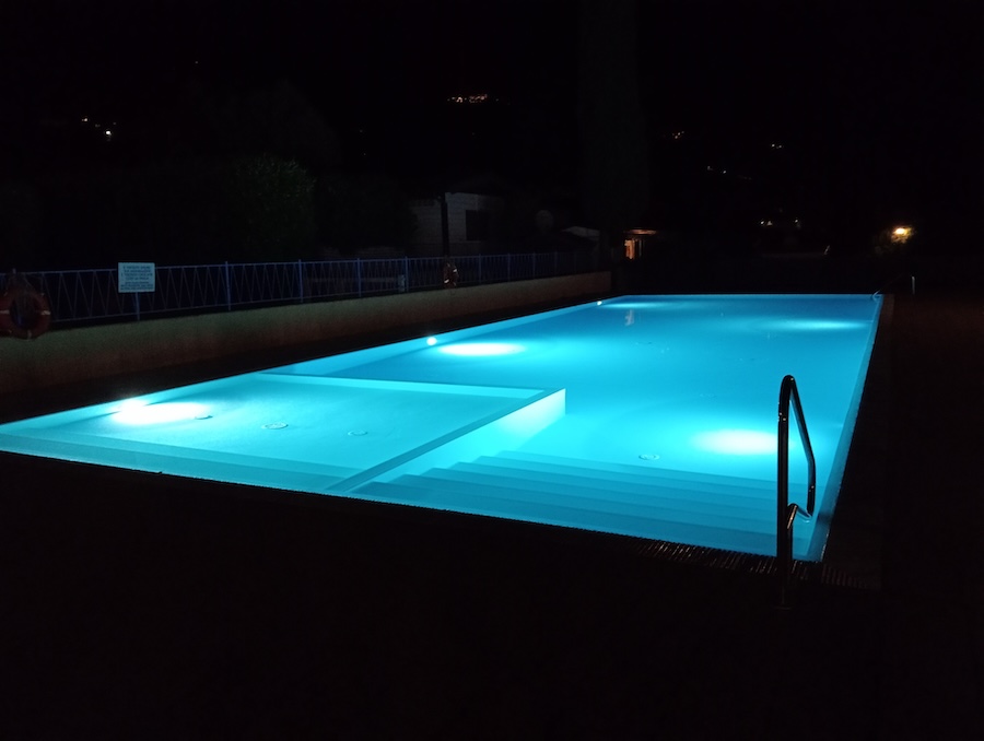 View of a swimming pool light from underwater at night.