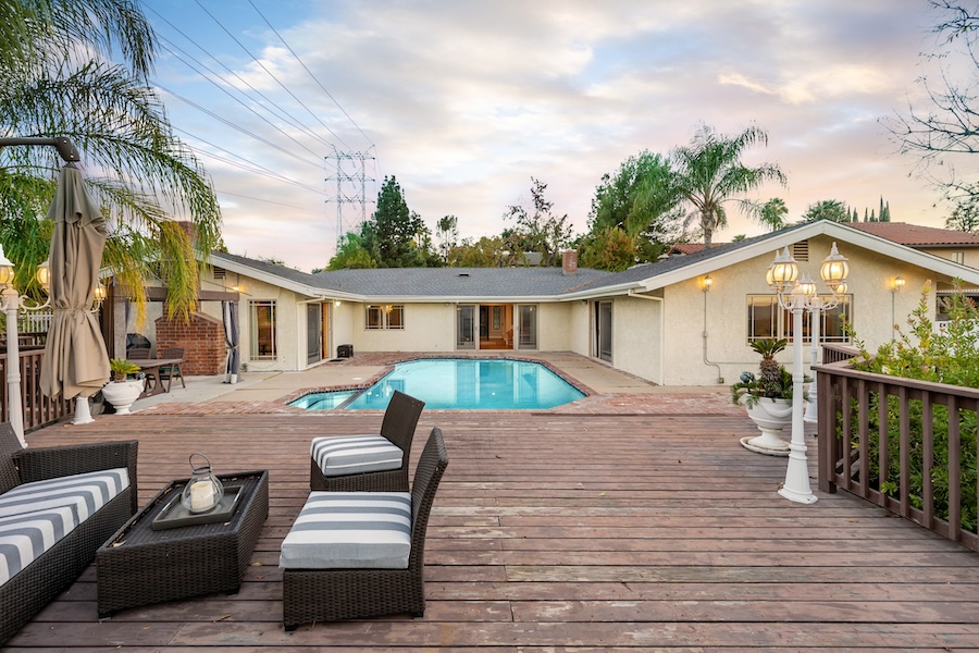 A rear view of a house with a swimming pool and patio