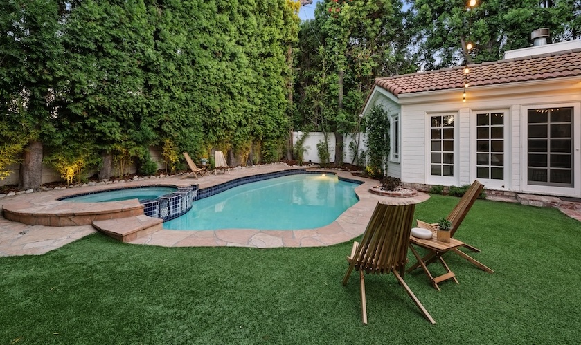 Enchanting two-story traditional with gated curb appeal, a private pool, spa, turf lawn, and cozy string-lit outdoor entertaining area.