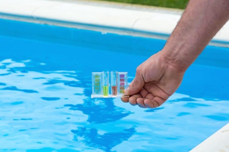 Tester for pool, hand against the background of the swimming pool.